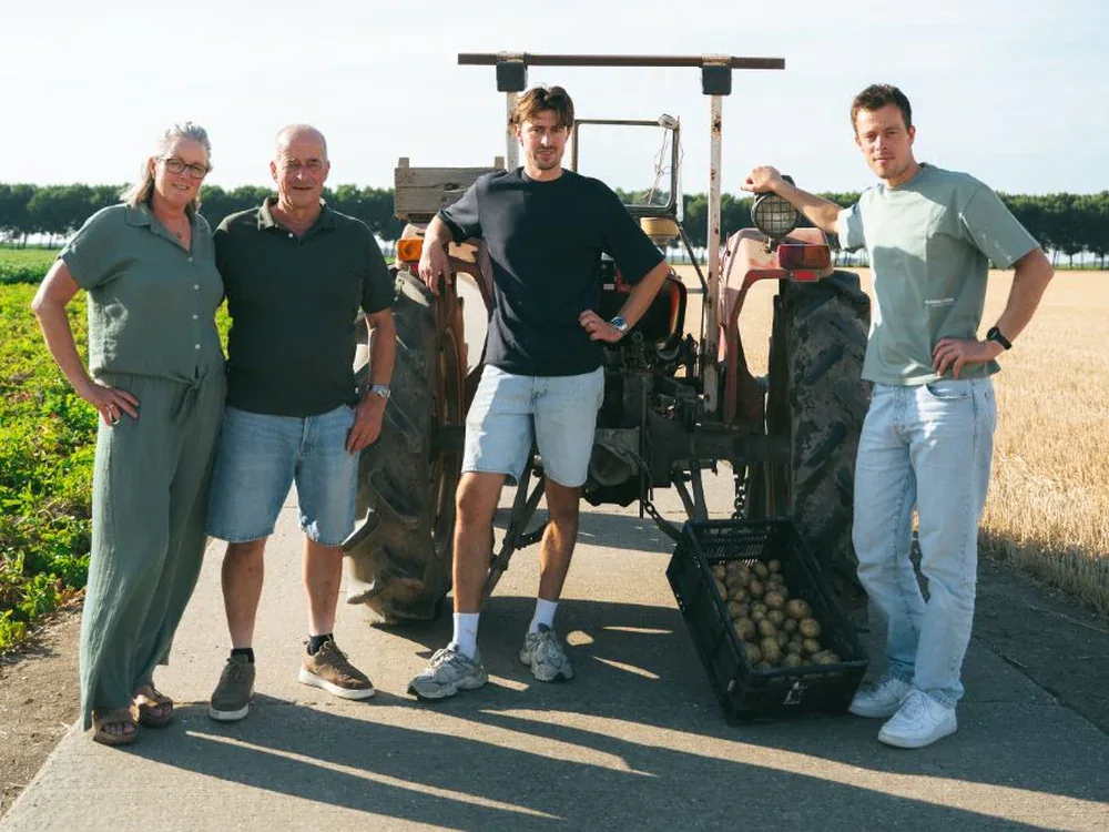 De familie Van Beusichem bij de trekker op het land in Zeewolde