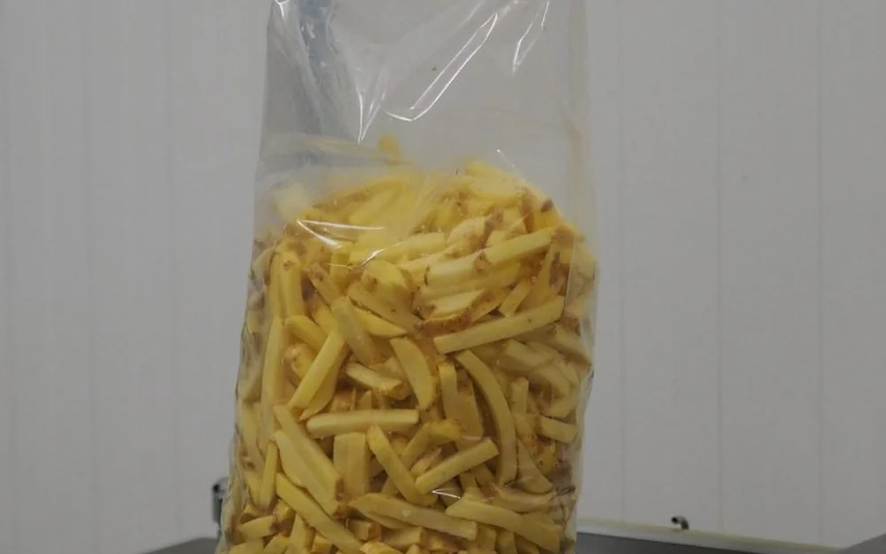 Zak vers gesneden friet op de vacuümmachine
