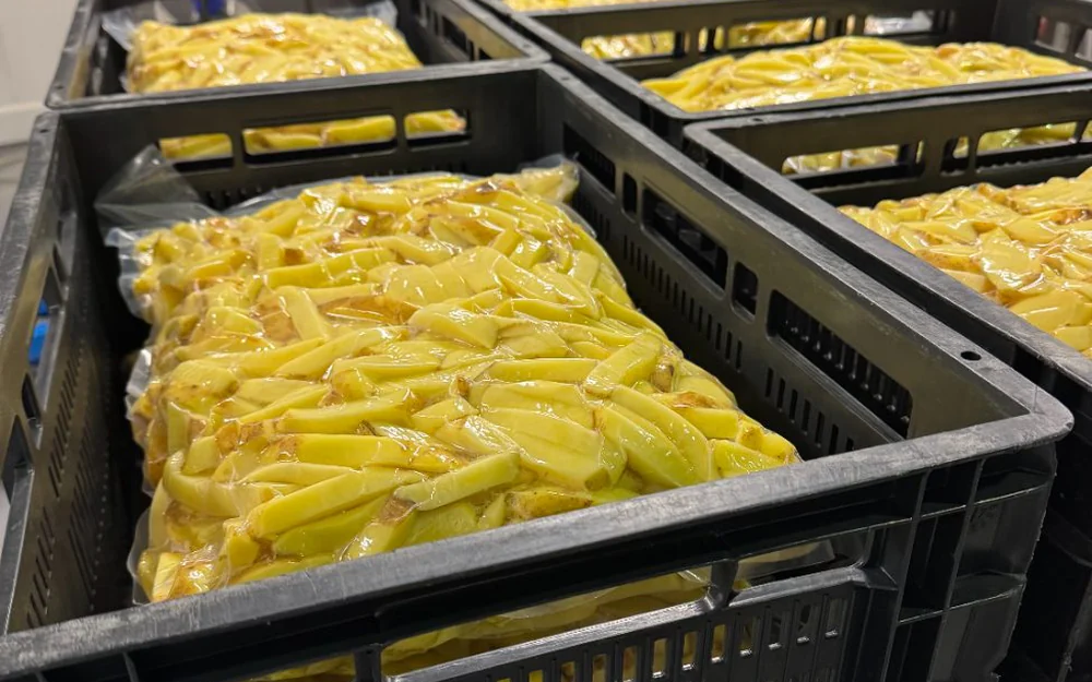 Kratten met vacuüm verpakte vers gesneden friet met schil
