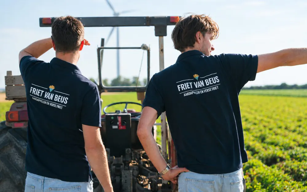 Thijs en Joost bij de trekker op het land